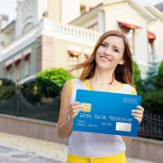 woman holding big banking card